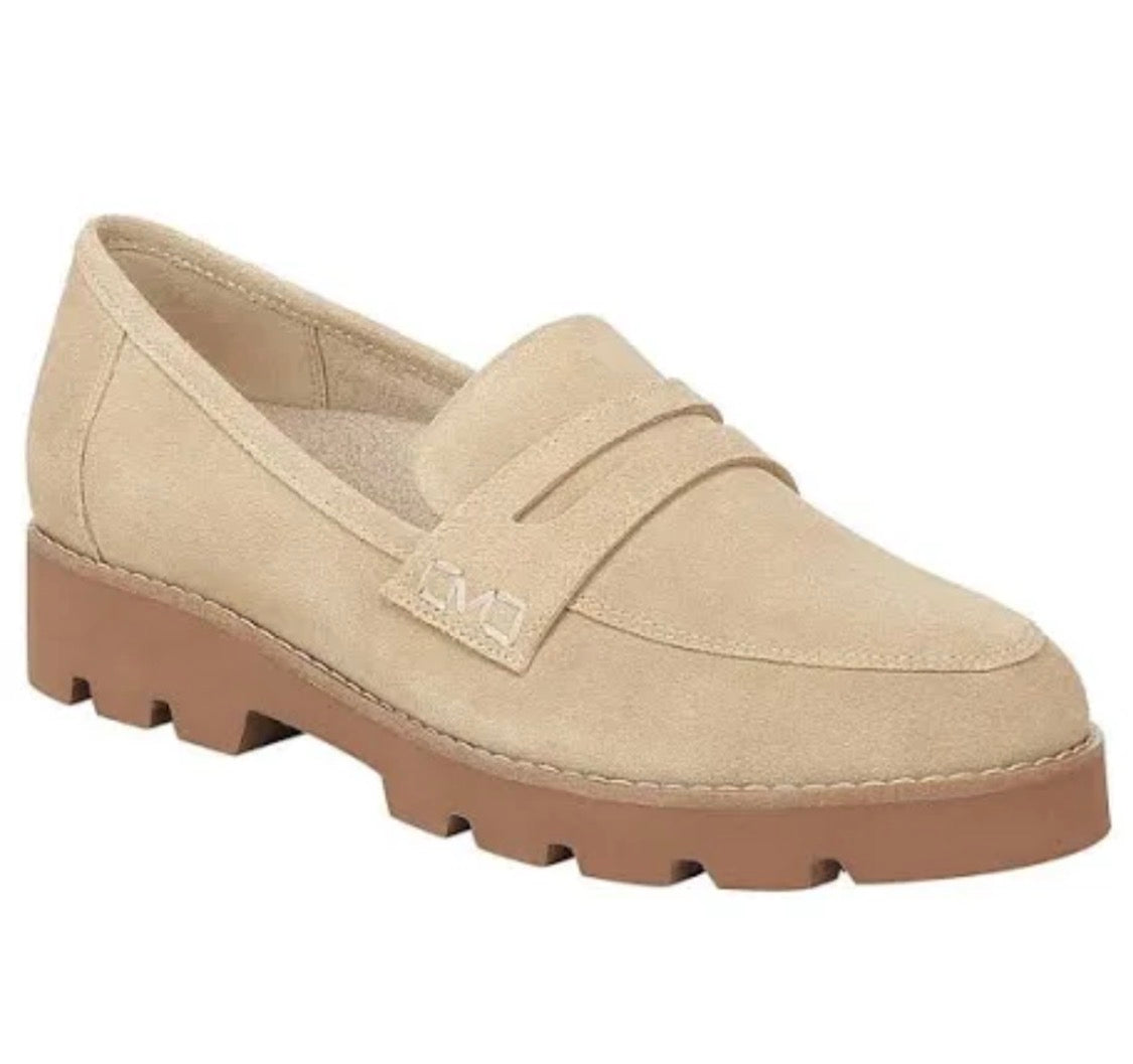 A light beige suede penny loafer with a chunky brown lug sole, shown from a three-quarters angle on a white background.