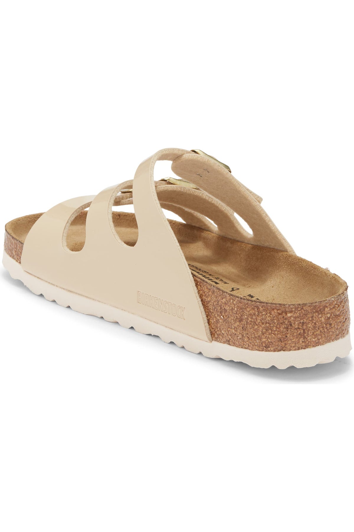 A single beige leather slide sandal with cutout straps, a cork midsole, and a white outsole, shown from a side-angle view on a white background.