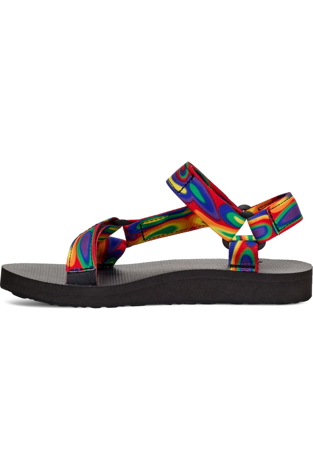 A single T-eeLo sandal shown from the side profile against a solid white background. The sandal features a black footbed and sole, with vibrant, multicolored rainbow-patterned straps.
