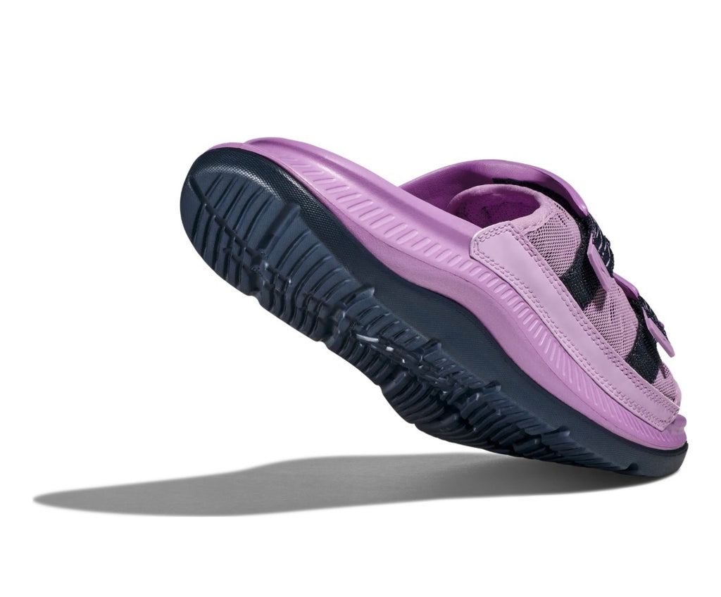 Close-up of HOKA logo on purple cushioned footbed of Ora Luxe recovery slide