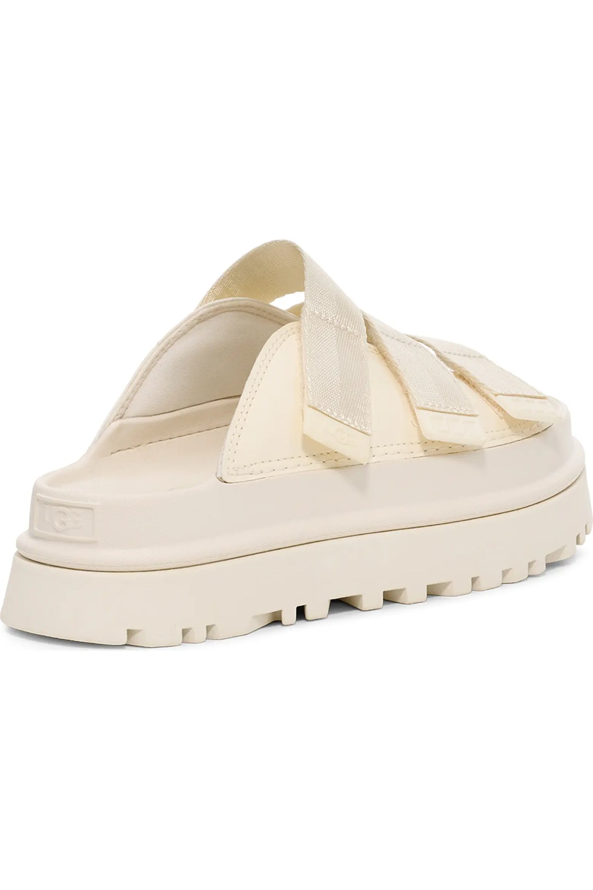 A cream-colored UGG platform mule sandal with wide woven straps and a chunky lug sole, shown from a three-quarters angle on a white background.