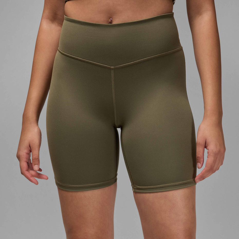 Person wearing olive green athletic shorts on a gray background